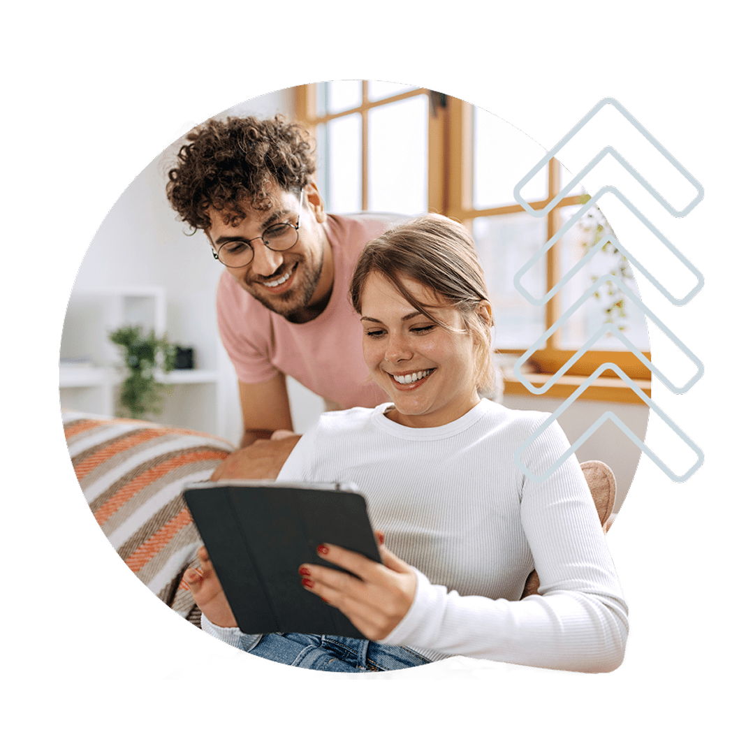 A smiling woman using a laptop, analyzing her dashboard while discussing her investment portfolio with a financial advisor